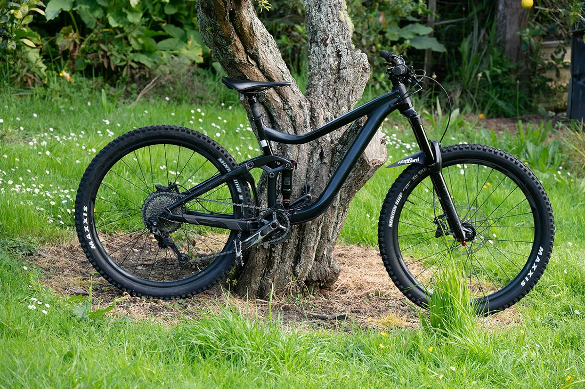 black bike with green lush grass in background, black mountain bike